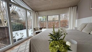 A bedroom with a large bed, a window, and a view of the outdoors. - 4 Star Holiday Home in Jaegerspris (Jægerspris)