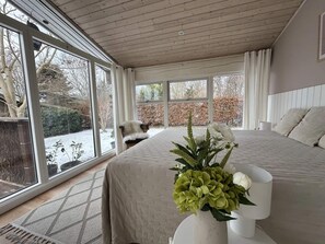 A bedroom with a large bed, a window, and a view of the outdoors. - 4 Star Holiday Home in Jaegerspris (Jægerspris)
