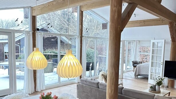 A spacious room with large windows, a wooden ceiling, and a cozy seating area. - 4 Star Holiday Home in Jaegerspris (Jægerspris)