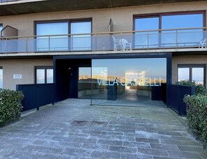 Ein modernes Gebäude mit Glasfassade, einem Balkon mit Sitzgelegenheiten und einem Schild mit der Aufschrift 'VILLA CASTELLI'.