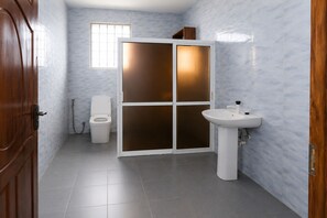 Ein Badezimmer mit Toilette, Waschbecken und einer Schiebetür.