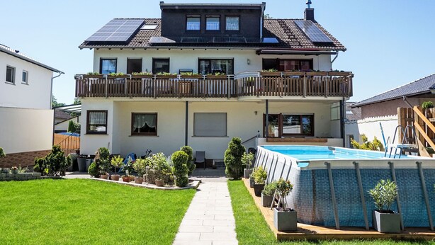 A two-story house with a swimming pool, a covered patio, and a well-maintained lawn. - Apartment Jessy by Interhome (Gau-Algesheim)
