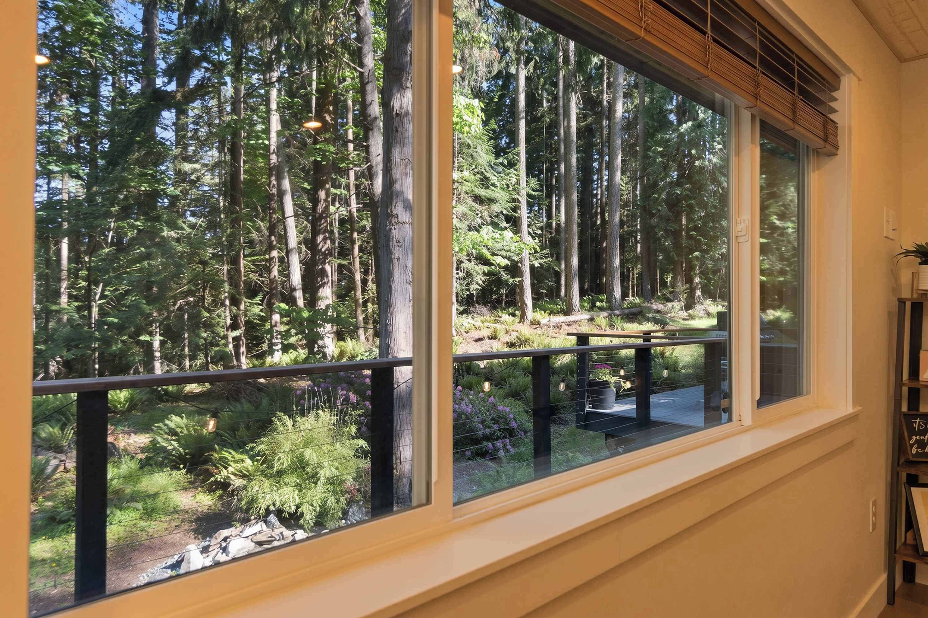 A room with a large window overlooking a forested area.