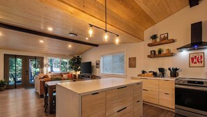 Eine moderne Küche mit Holzausbau, einer zentralen Kochinsel und einem Einbauofen.