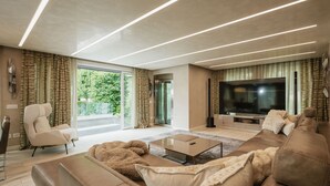 Una sala de estar moderna con un sofá, un sillón y un televisor de pantalla plana.
