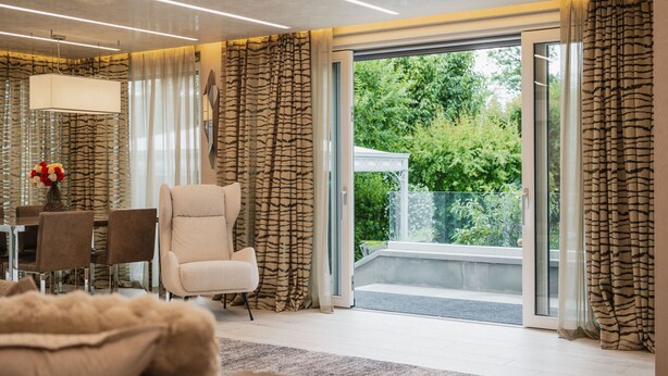 Una sala moderna con un sofá, un sillón y una mesa de comedor.