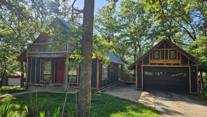 A cabin with a front porch, a garage, and a deck. - 3-Bedroom private lake cabin with access to state park and boat ramp (Pittsburg)