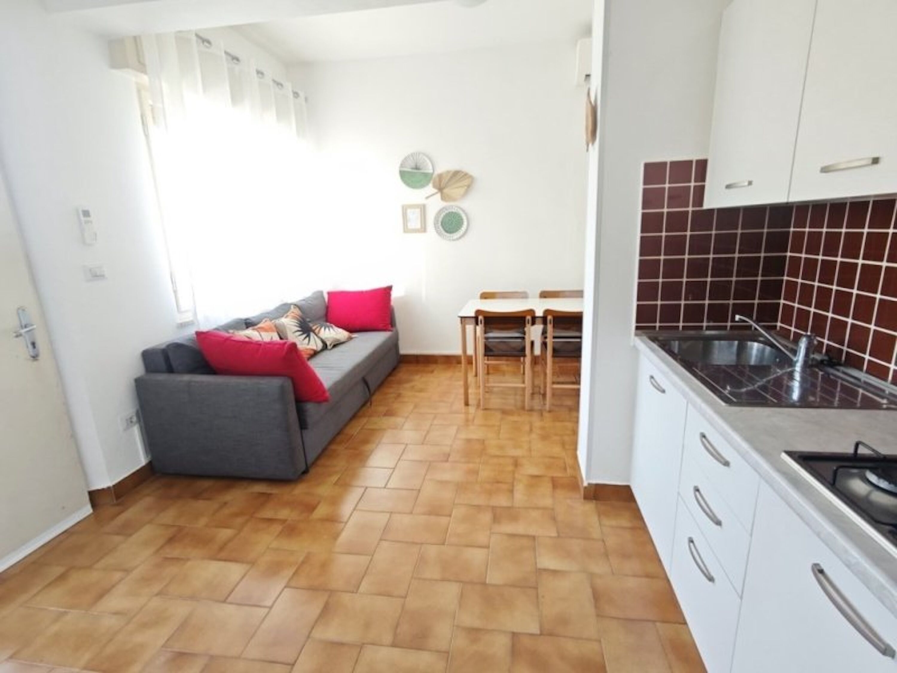 Ein kompakter Wohnbereich mit Sofa, Esstisch und Küchenzeile.