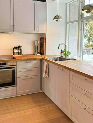 Eine moderne Küche mit Einbauofen, Spüle und Fenster mit Blick.