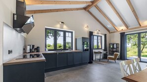 A modern kitchen with a large island, built-in appliances, and large windows. - Exclusive vacation home in first occupancy with unobstructed views of the Salzhaff (Am Salzhaff OT Pepelow)