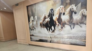 Un gran mural de caballos en movimiento sobre una pared en un pasillo.