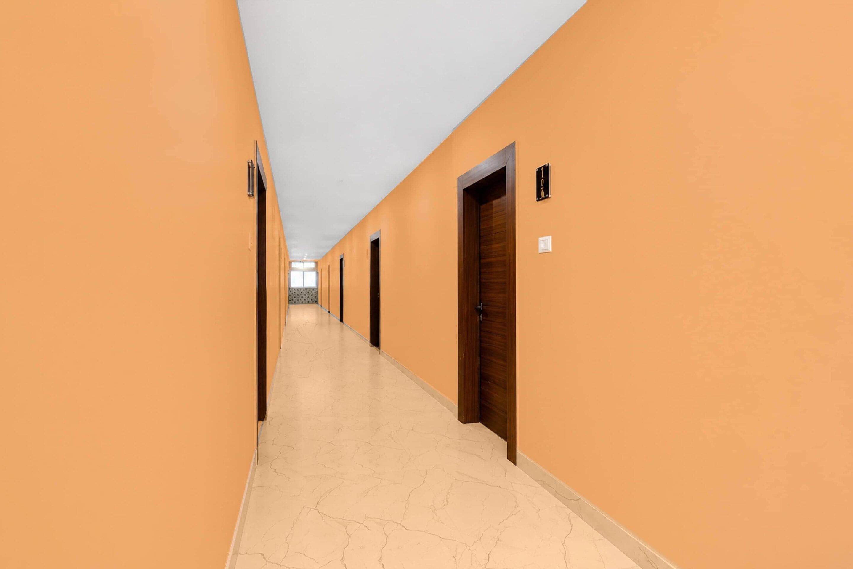 A long, narrow hallway with doors on both sides, leading to individual rooms.