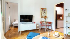 A compact living space with a bed, a TV, a dining area with chairs, a small table, and a kitchenette. - Your Haven in Kolonaki - Your home away from home - Didotou 1Br (Athina)