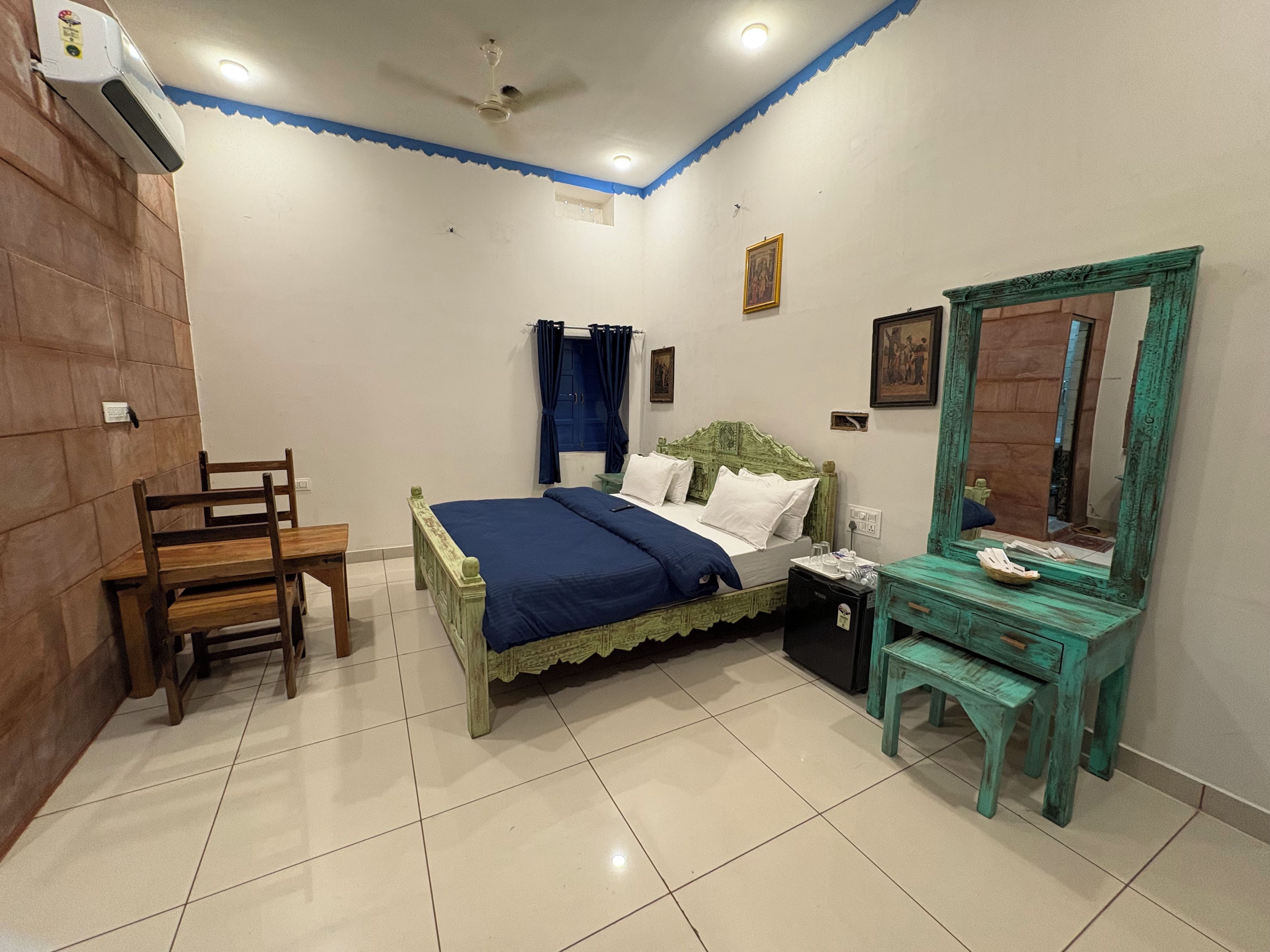 A bedroom with a bed, a chair, a dresser, a mirror, and a ceiling fan.
