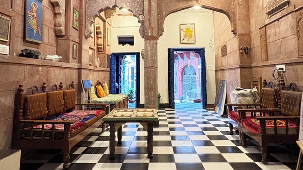 A room with a checkered floor, wooden furniture, and traditional decor.