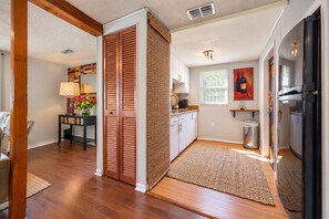 A modern kitchen with a built-in refrigerator, wooden cabinets, and a window with blinds. -     Good Vibes Cottage Private 1BR Retreat Just 1 Block from Bayshore (Tampa)