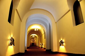 A corridor with arched ceilings and wall-mounted light fixtures. - Double Room - Tampu Hotel (Cusco)