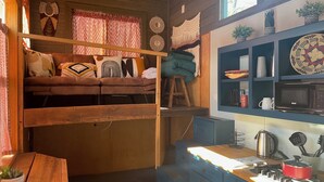 Een kleine keuken met een houten tafel, een fornuis en een magnetron.