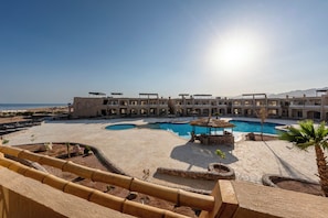 Ein Resort mit Pool, überdachtem Bereich und Meerblick.