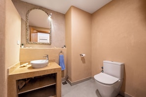 Ein Badezimmer mit Waschbecken, Spiegel, Toilette und Handtuchhalter.