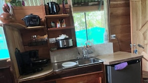 Una cocina compacta con fregadero, estufa y varios electrodomésticos.
