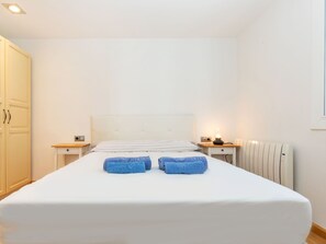 A hotel room with a large bed, two bedside tables, a wardrobe, and a radiator. - Sant Eloi by Interhome (Tossa de Mar)