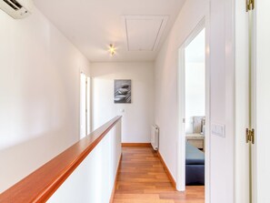 A hallway with a wooden railing, a radiator, a light fixture, and a framed picture on the wall. - La Suntuosidad – Torremirona by Interhome (Navata)