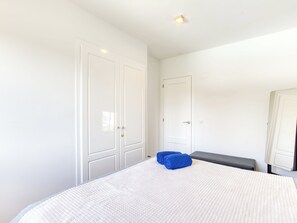 A bedroom with a large bed, a bench, and two doors. - La Suntuosidad – Torremirona by Interhome (Navata)