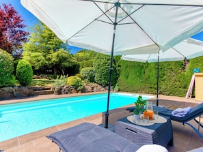 A swimming pool with lounge chairs and umbrellas, surrounded by a landscaped garden. - La Suntuosidad – Torremirona by Interhome (Navata)