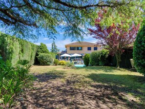 A house with a swimming pool, surrounded by a well-maintained garden and a tall hedge. - La Suntuosidad – Torremirona by Interhome (Navata)