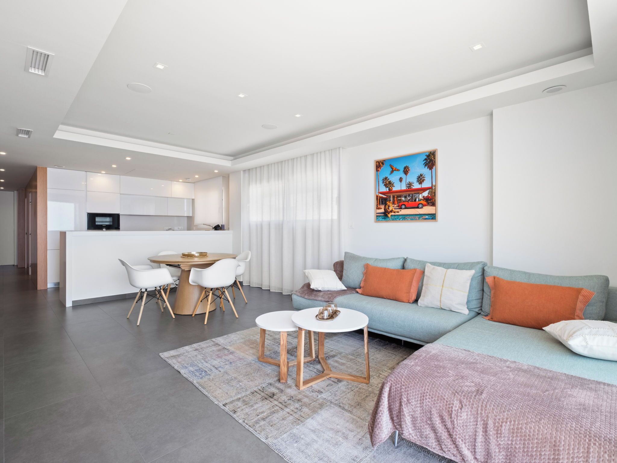 A modern living room with a sofa, coffee table, and dining area.