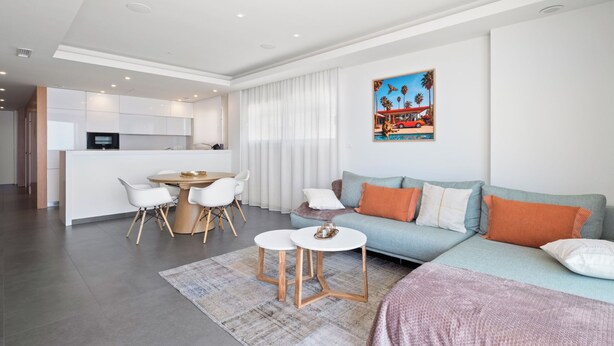 A modern living room with a sofa, coffee table, and dining area. - Blue Infinity I by Interhome (Moraira)