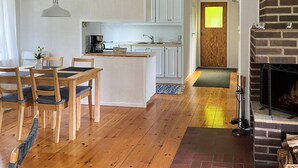 Een moderne keuken met witte kasten, een centraal eiland en een eetgedeelte met houten stoelen.
