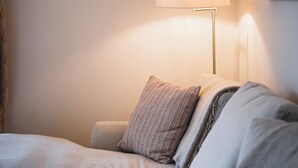 Ein ordentlich eingerichtetes Schlafzimmer mit einem Bett, Kissen, einer Lampe und einem Bild an der Wand.