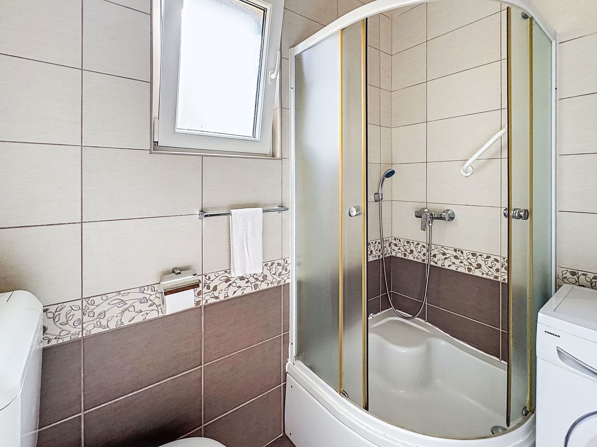 Ein Badezimmer mit Dusche, Toilette und Waschbecken.