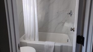 A bathroom with a bathtub, a shower, and a toilet. - Mountain Inn (Gatlinburg)