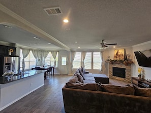 A spacious living area with a sofa, fireplace, and a kitchen area with a dining table.