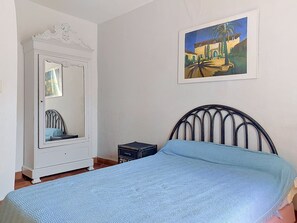 A bedroom with a bed, a dresser, a small table, and a painting on the wall. - Chateau Payan by Interhome (Flassans sur Issole)