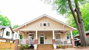 A two-story house with a front porch, a central door, and a small front yard. - Safe and quiet street. Walk to shops & more. Fenced in yard w huge front porch.  (Charlotte)