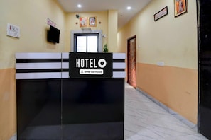 A hotel reception desk with a sign indicating OYO service. - Deluxe Room Chowdhury Guest House (Barakpur)