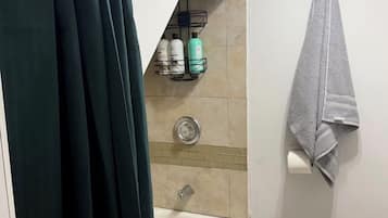 Een douche, handdoeken, zeep, toiletpapier