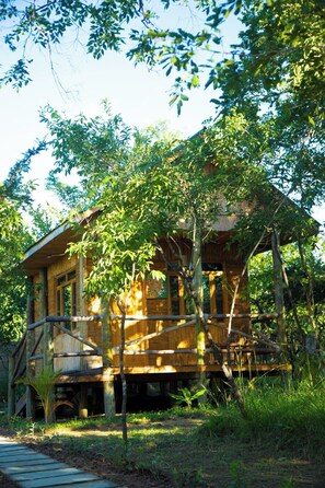 A rustic wooden cabin surrounded by trees. - TCTC & CAMP (Mikumi)
