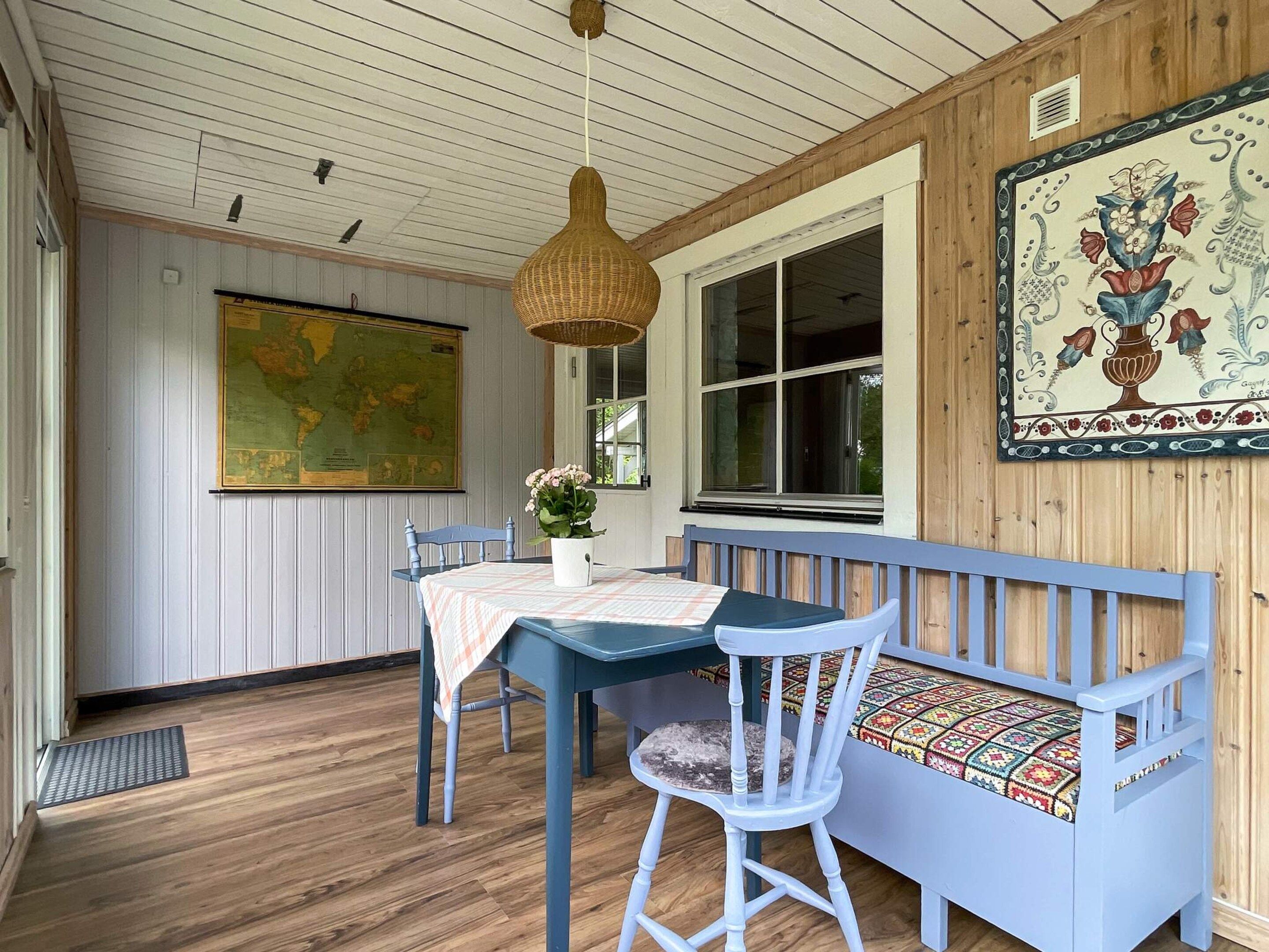 A room with a wooden bench, a table with a map, and a hanging light fixture.