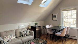 Ein Loft-Zimmer mit Essbereich, einer Couch und einem kleinen Tisch.