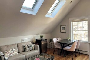 Una habitación estilo loft con comedor, sofá y una pequeña mesa.