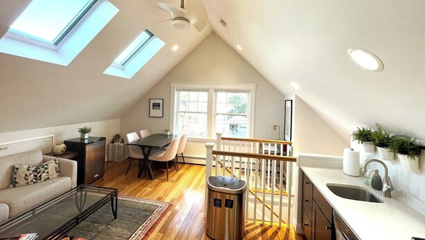 Eine Loft-Wohnung mit Skylights, einem Essbereich, einer Küche und einer Treppe.