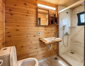A wooden-paneled bathroom with a sink, mirror, and shower. - YAKAMOZ BEACH (Marmaris)