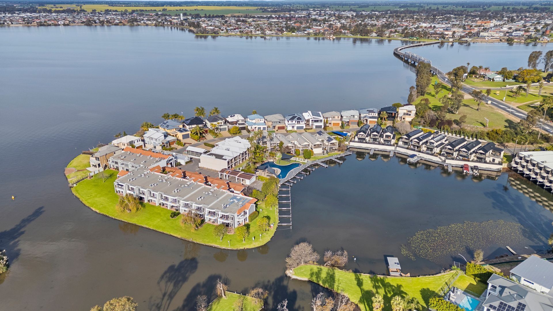 A residential area with houses, a bridge, and a body of water.