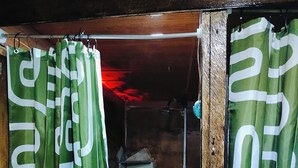 A doorway with green curtains featuring white patterns, a tiled floor, and a rustic interior with a metal shelf. - Celestial forest (Provincia de Alajuela)