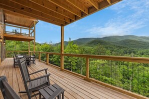 A wooden deck with outdoor seating, overlooking a mountainous landscape. - Pool Cabin with 5 King Bedrooms (Cosby)